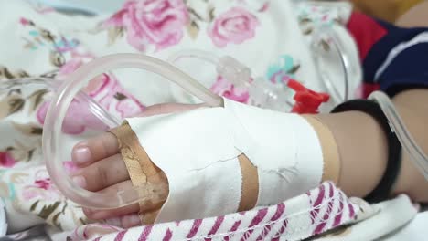 close up shot of iv infusion on bandaged hand laying on bed