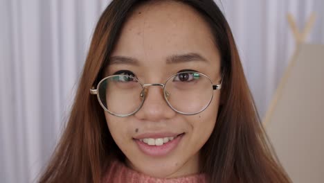 close up de mujer joven de oriente medio cara con gafas, chica, estudiante toma fotos en una cámara retro, presiona el obturador. fotógrafa toma la cámara y presiona el botón. cámara lenta