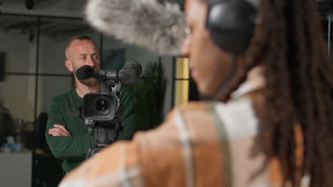 Grabador-De-Sonido-Masculino-Y-Operador-De-Cámara-Trabajando-En-Un-Set-De-Filmación-Filmando-Una-Película-O-Un-Video-En-El-Estudio