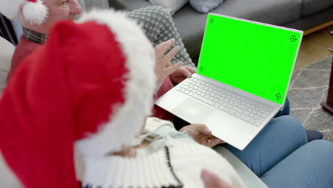 Happy-caucasian-couple-having-christmas-laptop-video-call-with-green-screen,-slow-motion