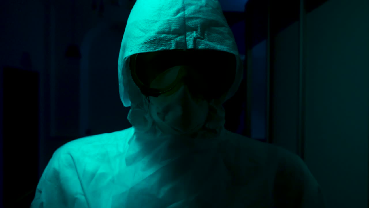 persona con equipo de protección en un cuarto oscuro