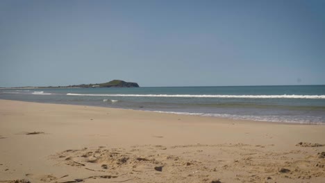 vista panorámica de una playa de arena suave mientras el océano se desliza por la orilla