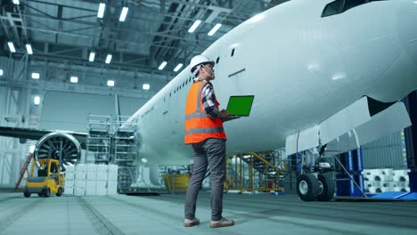 mantenimiento del avión en el hangar con ingeniero y portátil