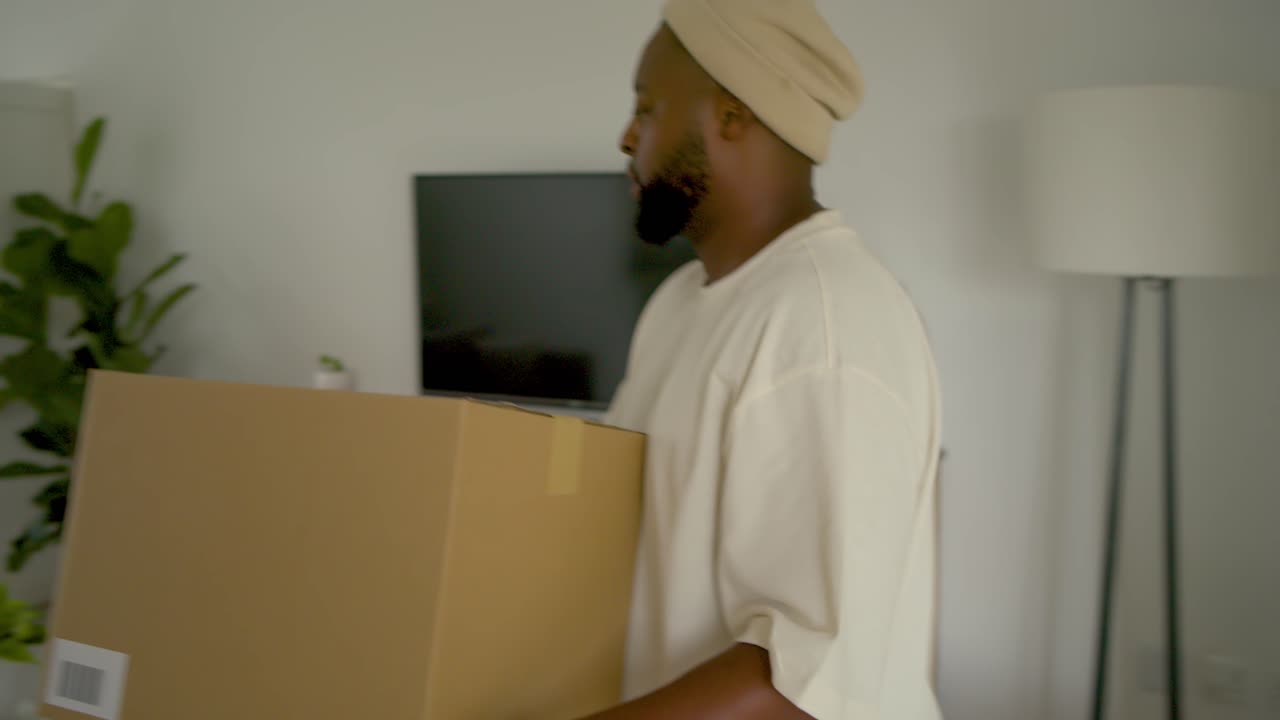Resident receiving delivery, carrying box through front door, placing on coffee table, inspecting