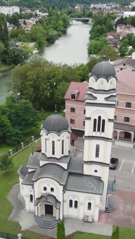 aerial view of a serbian orthodox church in banja luka, bosnia and herzegovina, highlighting its domes, bell tower, and surrounding landscape. vertical video