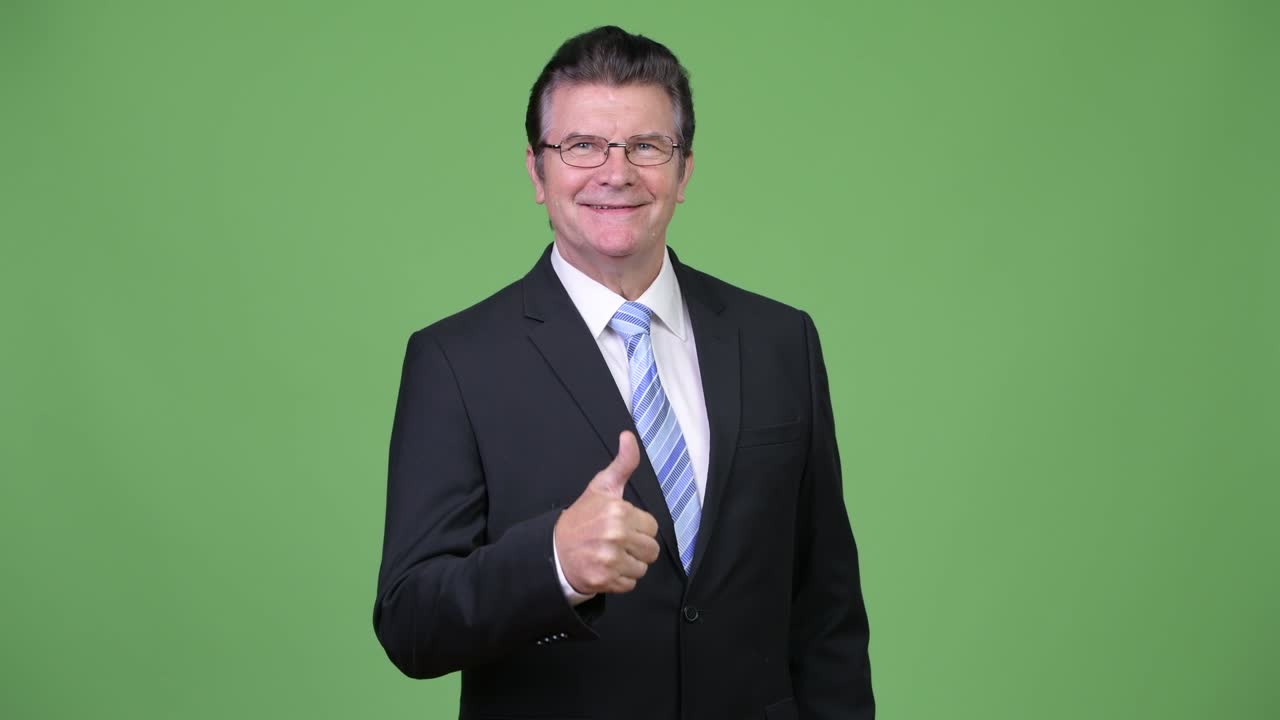 시니어 잘생긴 사업가가 엄지손가락을 올리고