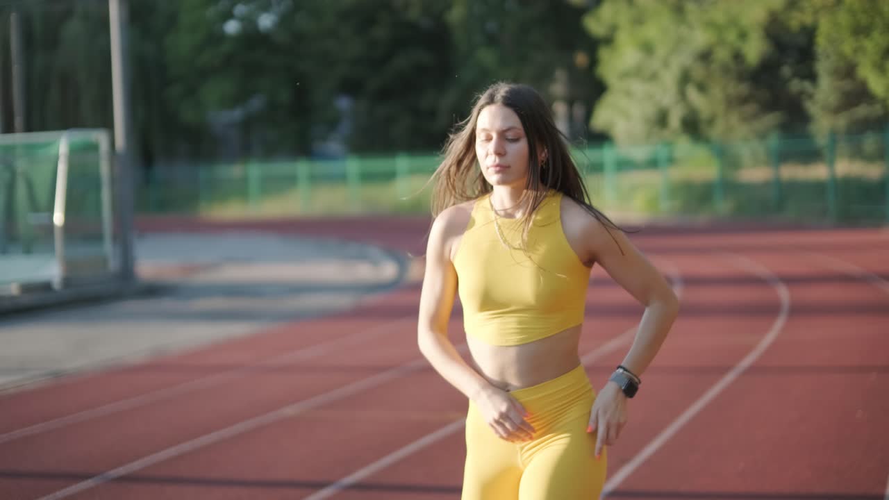 atleta femenina corriendo en pista al aire libre con ropa deportiva