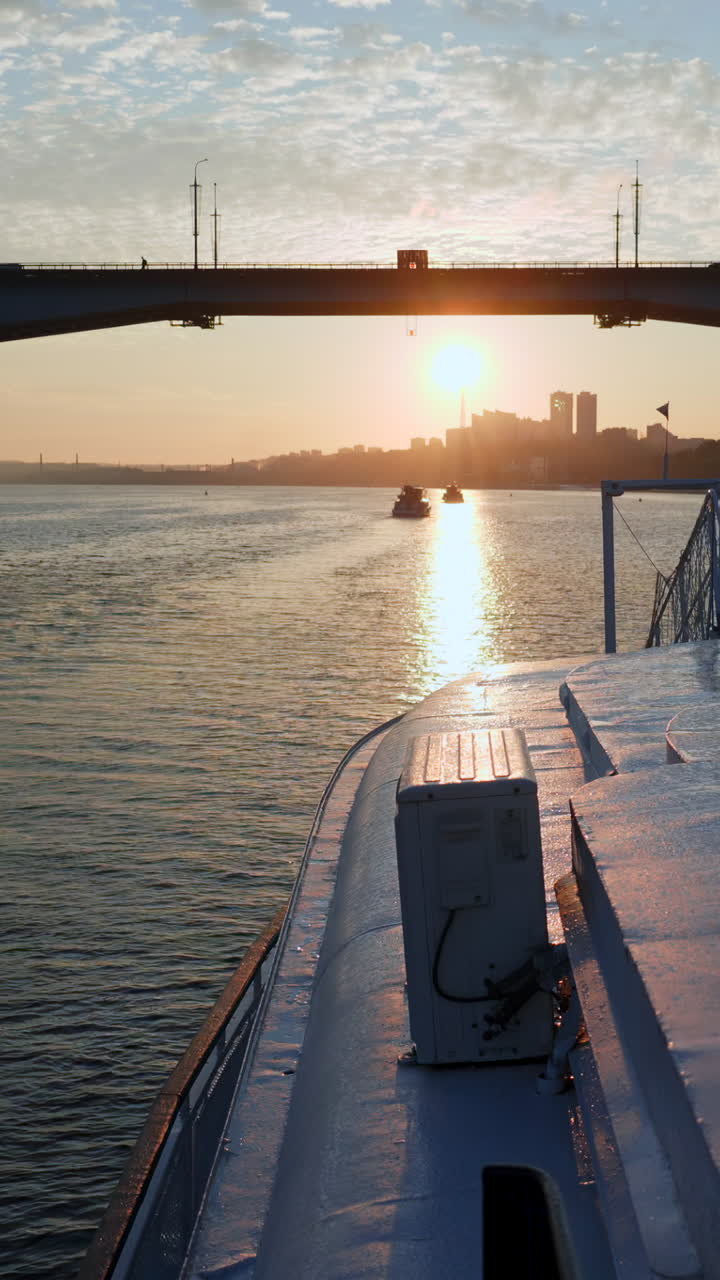Sonnenuntergang am Fluss mit Brücke und Stadtbild