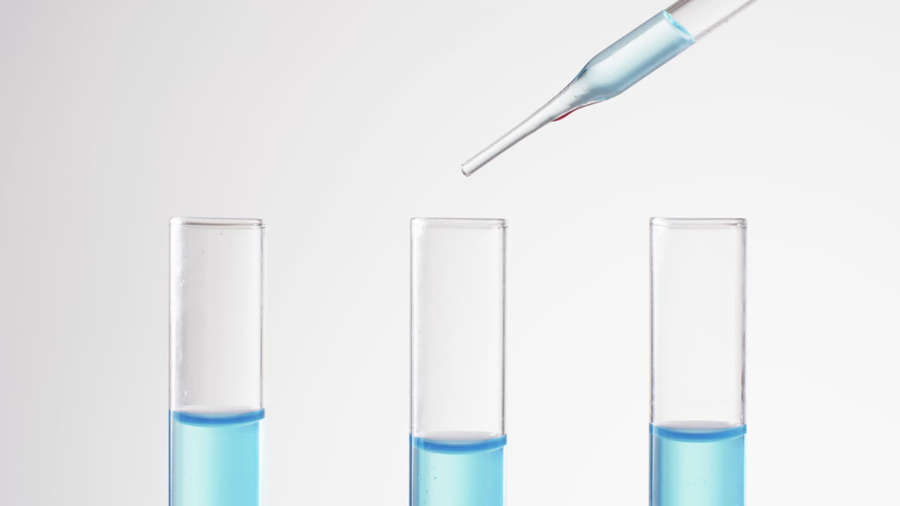 Video of glass laboratory test tubes and pipette with blue liquid and copy space on white background