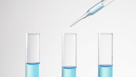 vídeo de tubos de ensayo de laboratorio de vidrio y pipeta con líquido azul y espacio de copia sobre fondo blanco
