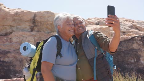 Feliz-Pareja-Birracial-Senior-En-Las-Montañas-Tomando-Selfie-Con-Smartphone,-En-Cámara-Lenta