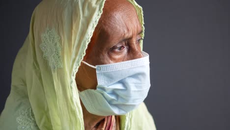 elderly woman wearing mask and hijab