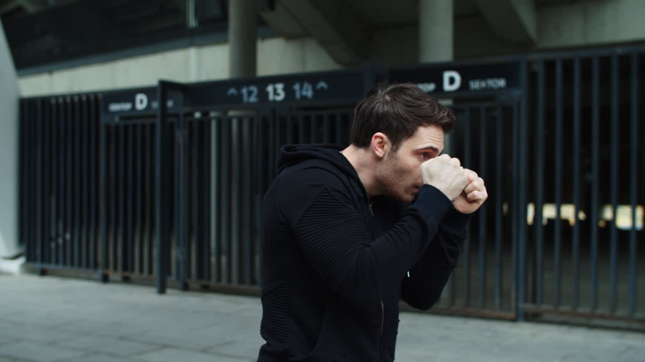 남성 권투 선수 훈련 상자 운동에서  ⁇ 치. 밖에서 권투하는 젊은 남자.