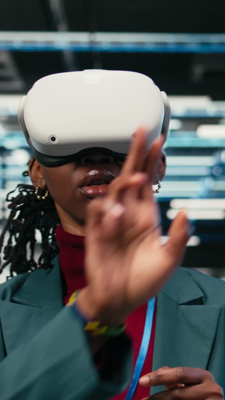 Vertikal video: Kvindelig ingeniør i datacentret tager VR-briller på for at optimere udstyr/rigge.