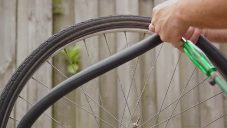 hand using compressor to inflate bicycle tire