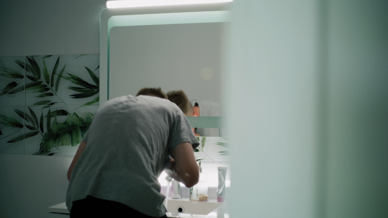 십대 가 화장실 에서 얼굴 을 고 있다