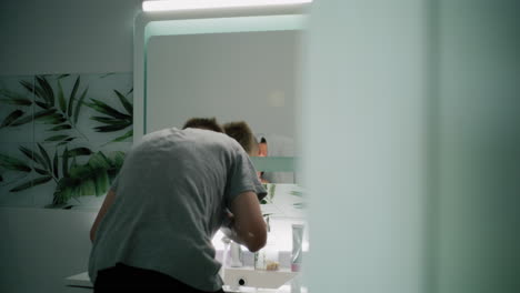 teenager washing face in bathroom