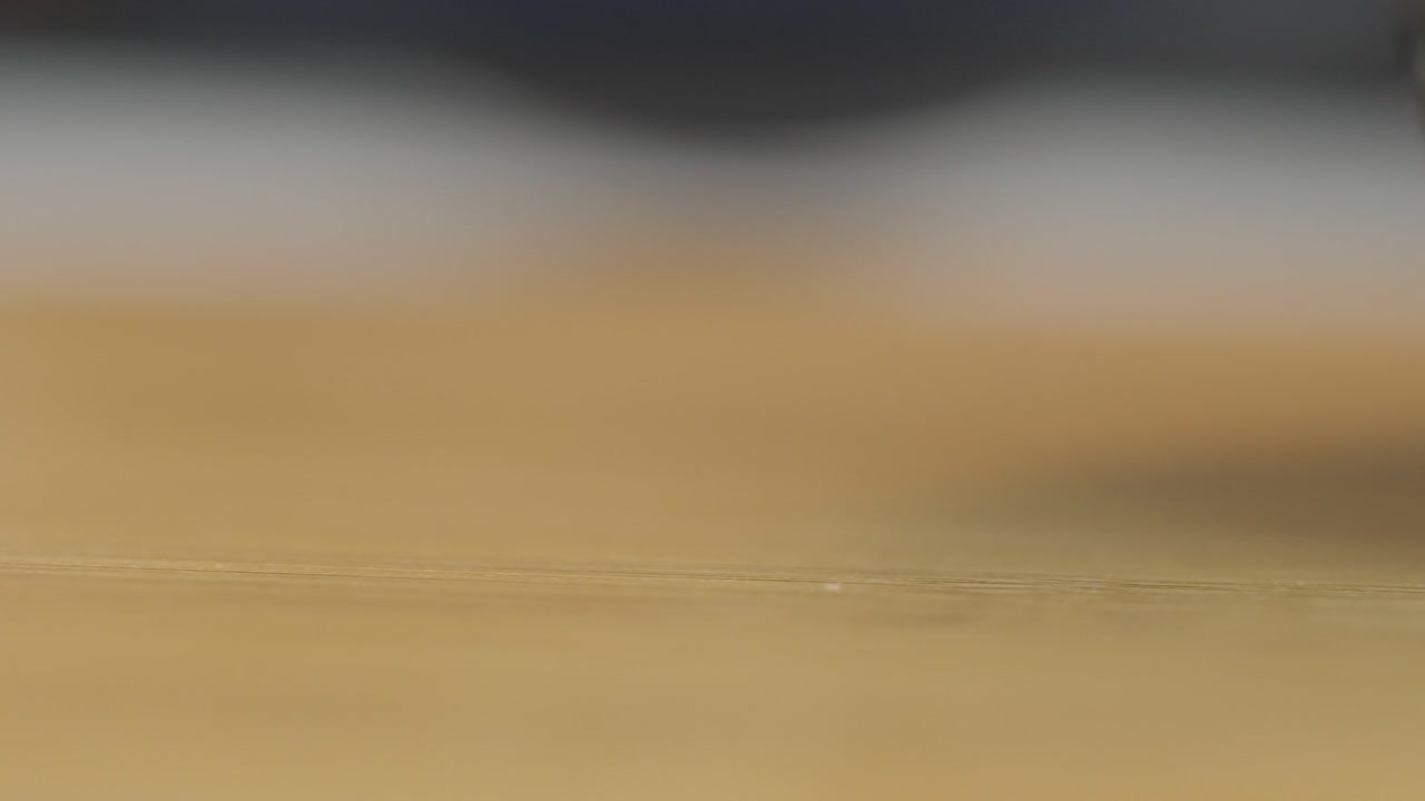 Detailed close-up shot of colorful marbles captured through a mesh net. The focus highlights the vibrant hues and glossy texture, creating an intriguing visual contrast