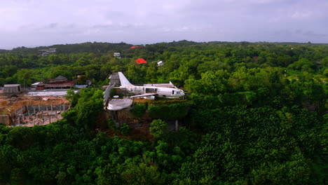 Repairing-of-retired-jet-plane-in-garden-on-steep-jungle-cliff,-Bali