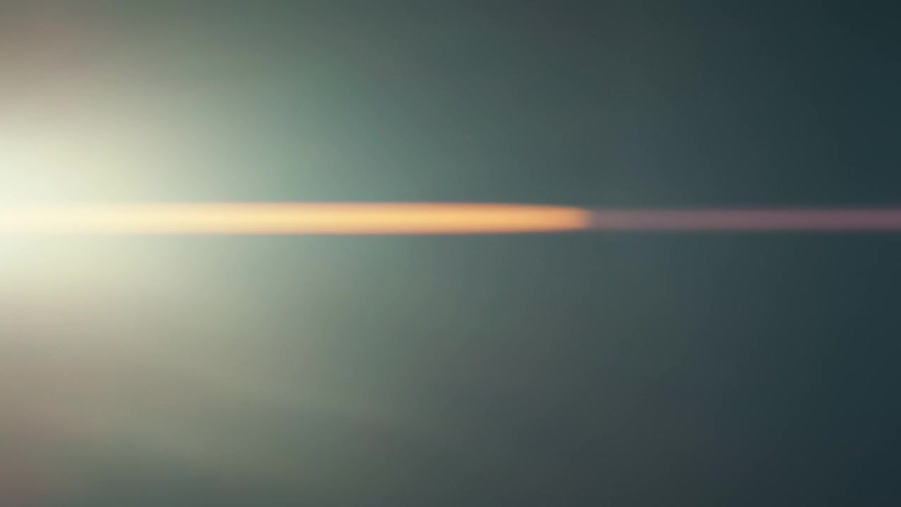Flare anamorfico con aloni di luce dorati orizzontali.