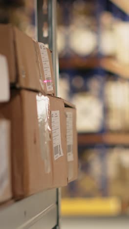 vertical video close up of black worker using a barcode scanner to process shipping labels