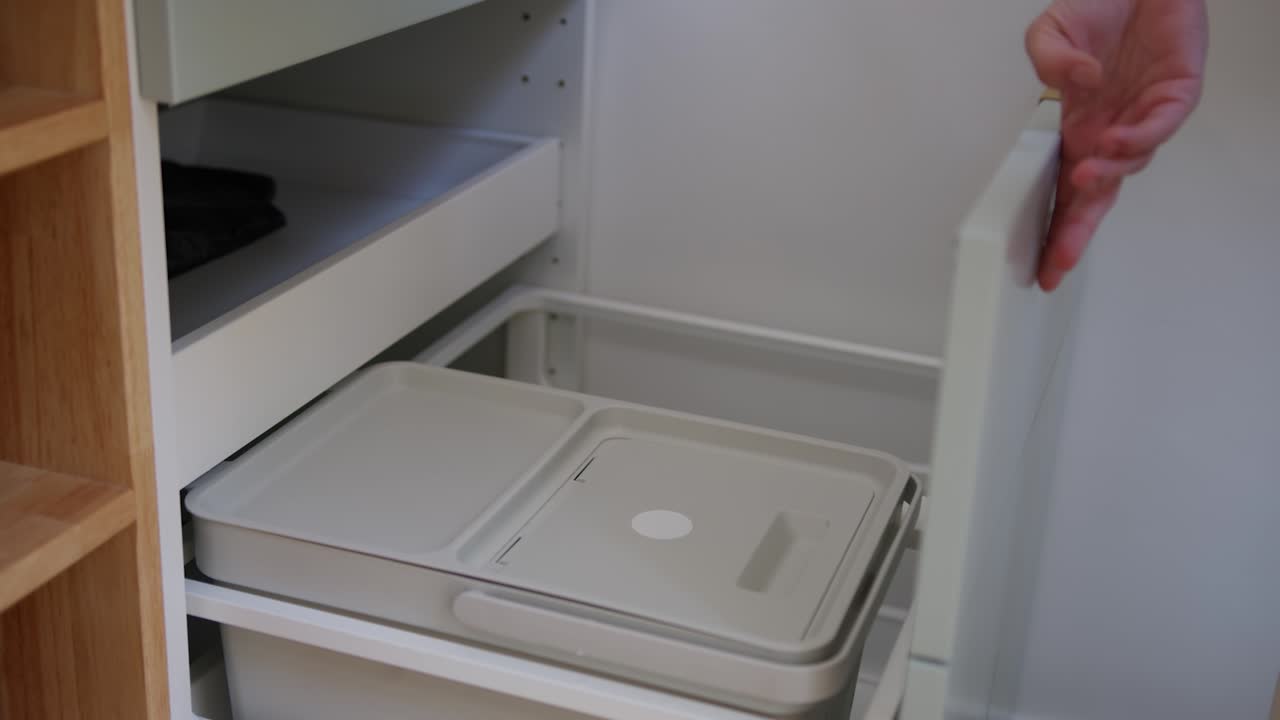 유기 쓰레기를 쓰레기통에 던지는 사람의 손, 가까운 시각