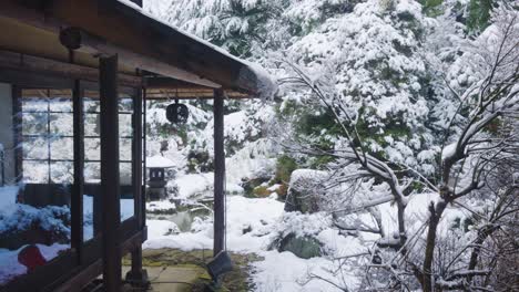 Posada-Ryokan-En-El-Norte-De-Japón,-Escena-Invernal-Mientras-La-Nieve-Cae-En-El-Jardín