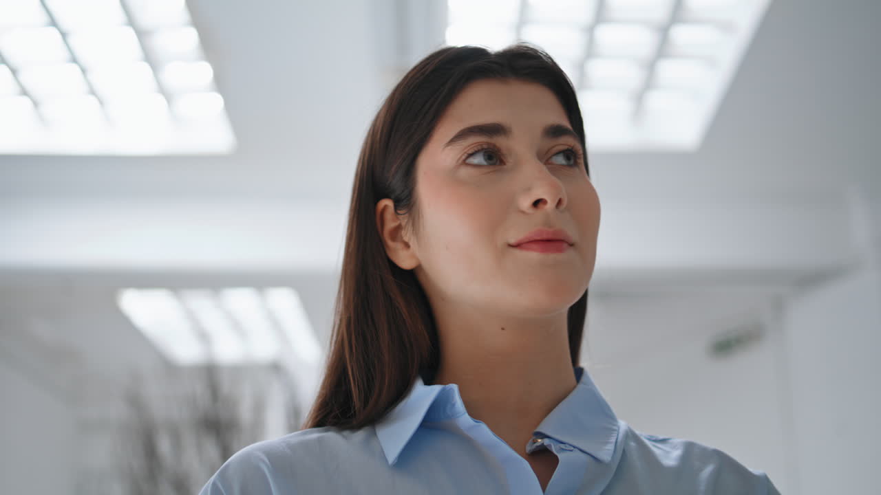 una hermosa chica de primer plano posando ajustando el cabello. una joven mujer de negocios en la oficina.