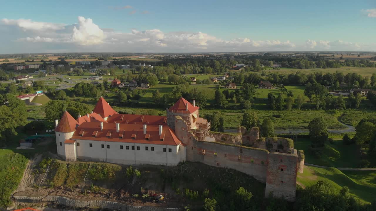 Ripresa aerea con drone ad alta quota sopra il castello di Bauska, Lettonia, in una soleggiata giornata estiva