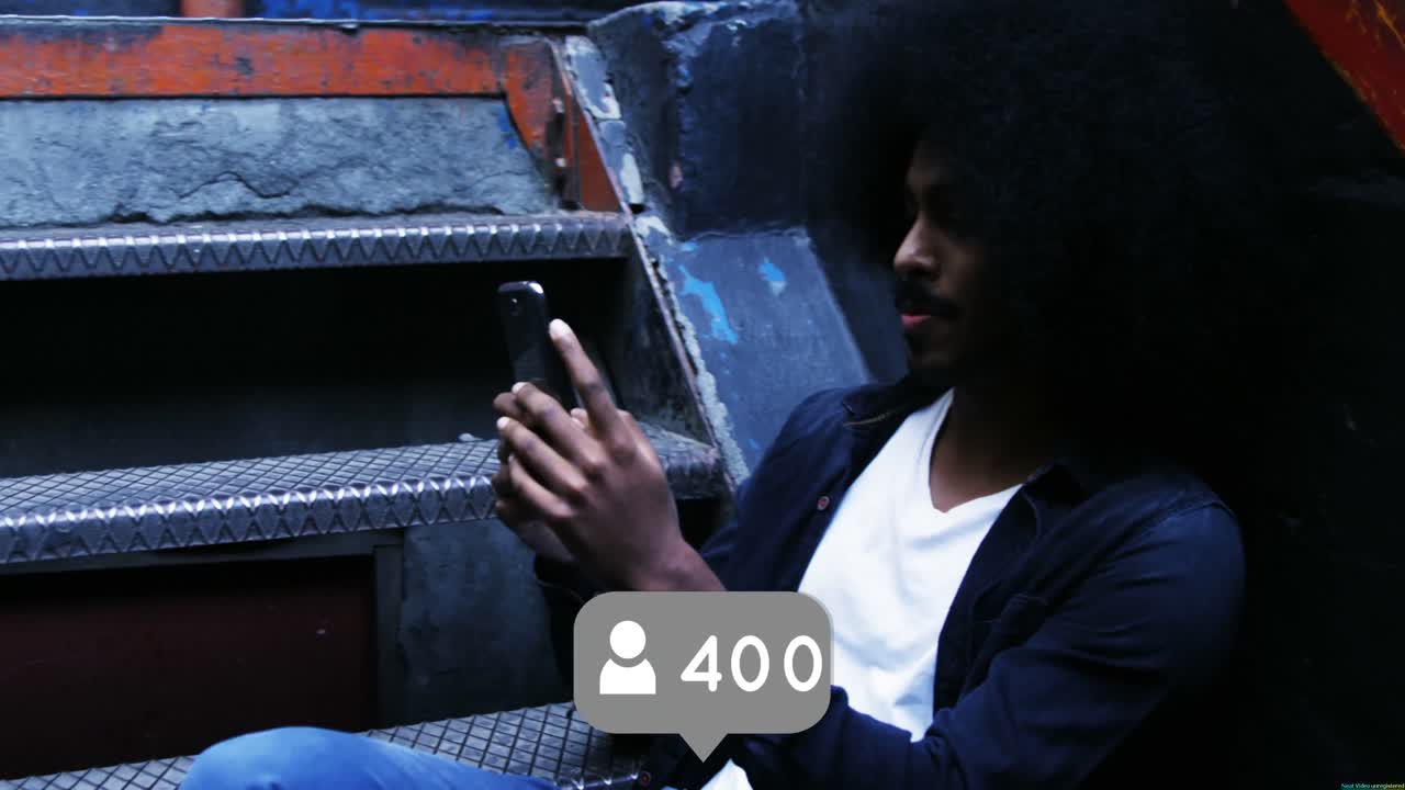 Black man with an Afro is sitting on the stairs 4k
