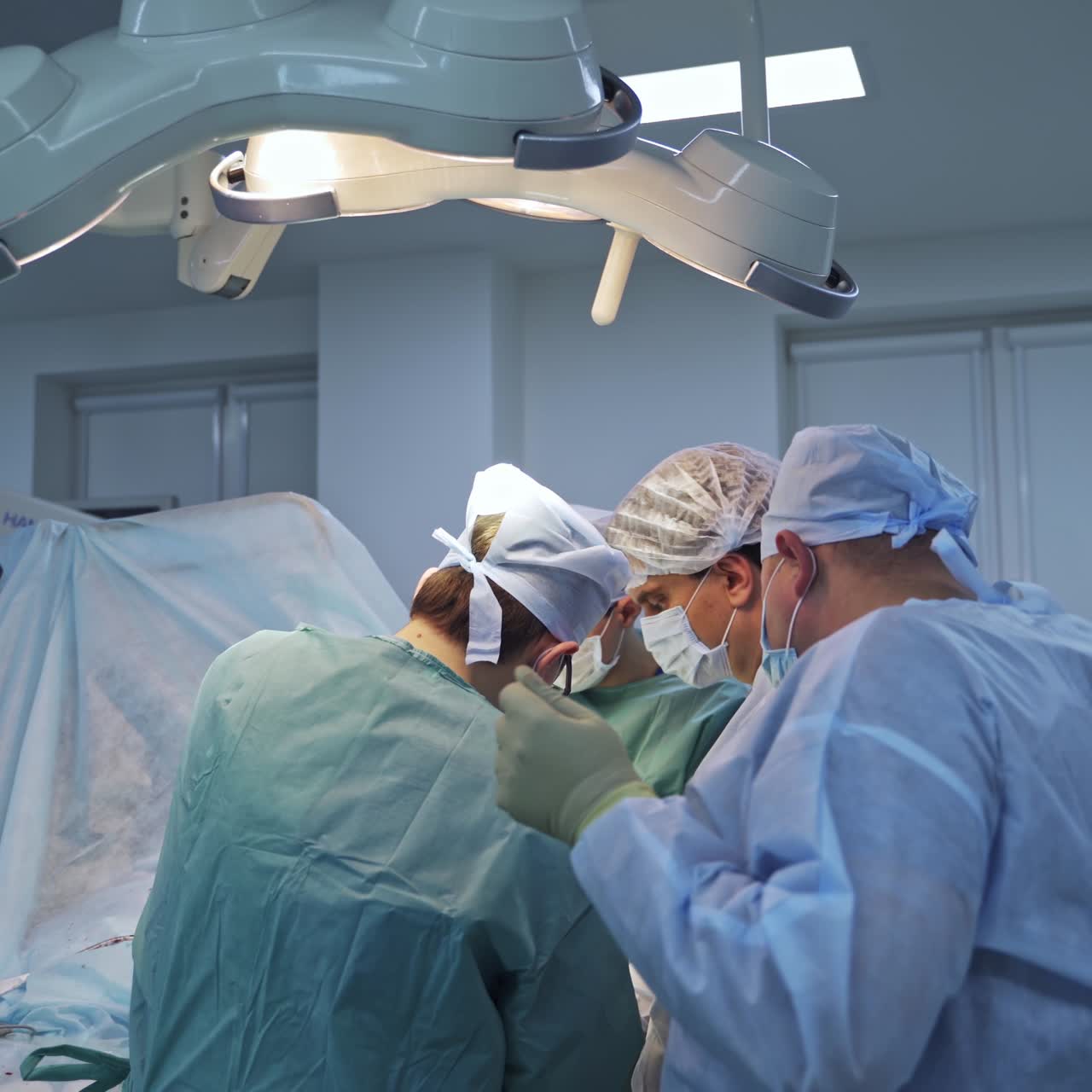 Operation teamwork in uniform. Surgery specialists operating in hospital room