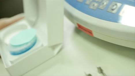 in a science laboratory, a scientist extracts a thin cotton pad in order to measure a substance