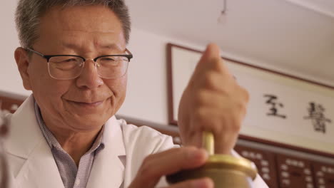 portrait traditional chinese medicine practitioner using special scales to weight dry plant roots treatment