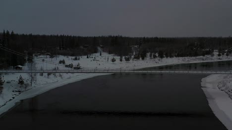 aerial view of suspension bridge over dark black river