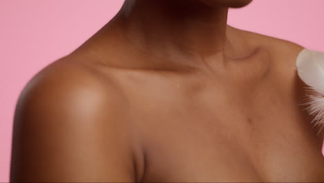 woman's shoulder and chest with feather