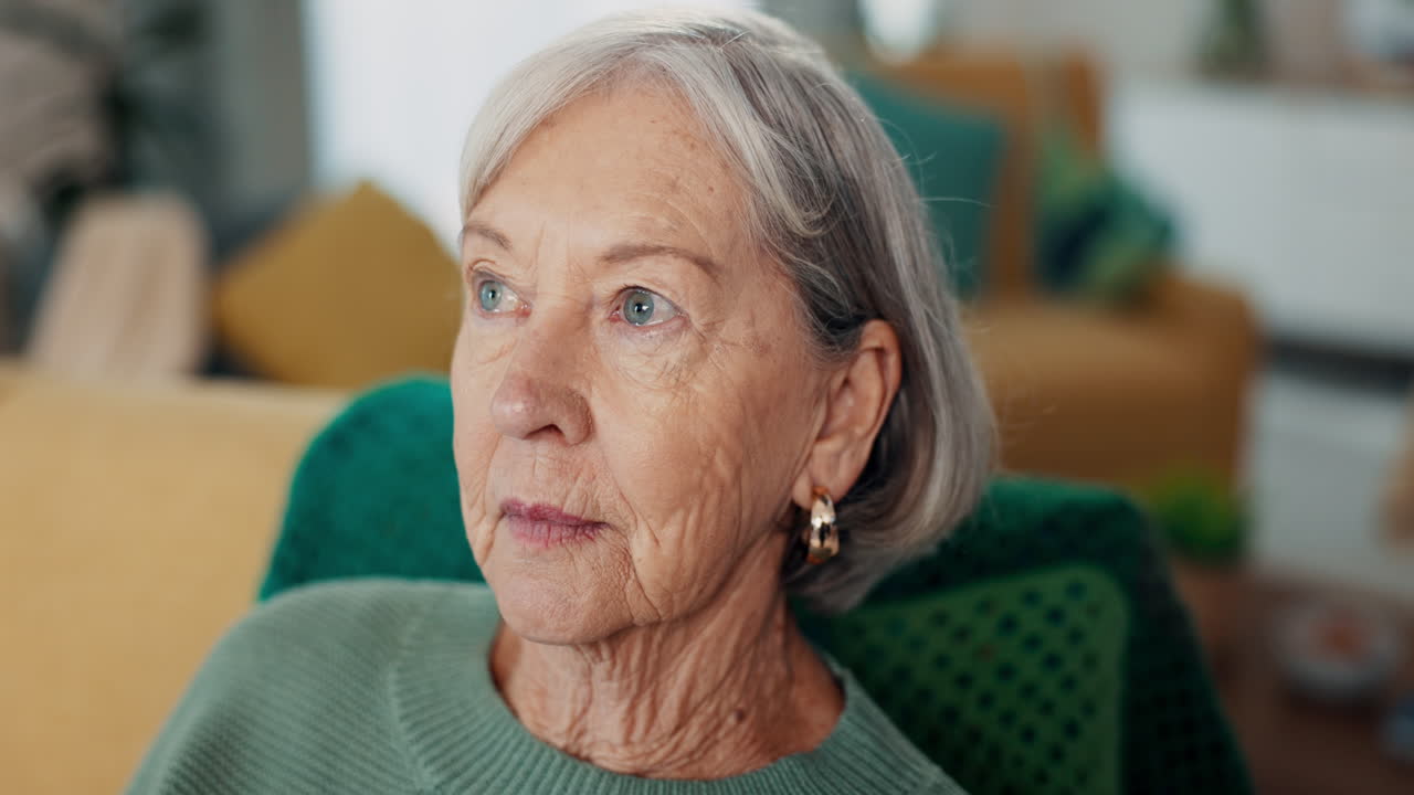 Face, anxiety and senior woman on a sofa thinking
