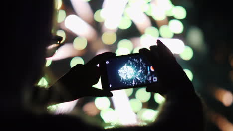 Eine-Frau-Bewundert-Das-Feuerwerk-Am-Nachthimmel-Mach-Fotos-Mit-Deinem-Smartphone