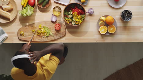 afro-american man cooking food and dancing in kitchen