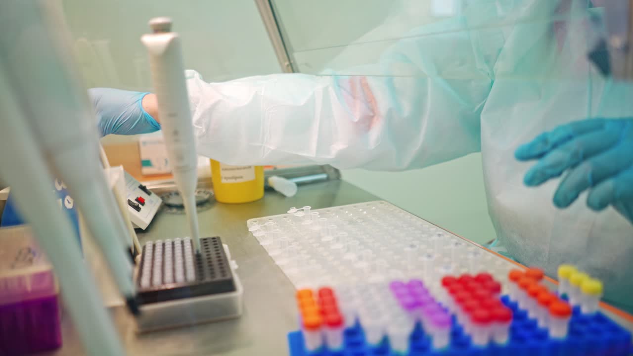 Research worker with medical instruments. Laboratory assistant drops some liquid into small vial on a table in clinic.