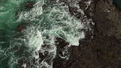 Rising-aerial-view-of-waves-crashing-along-Northern-California's-rocky-coastline