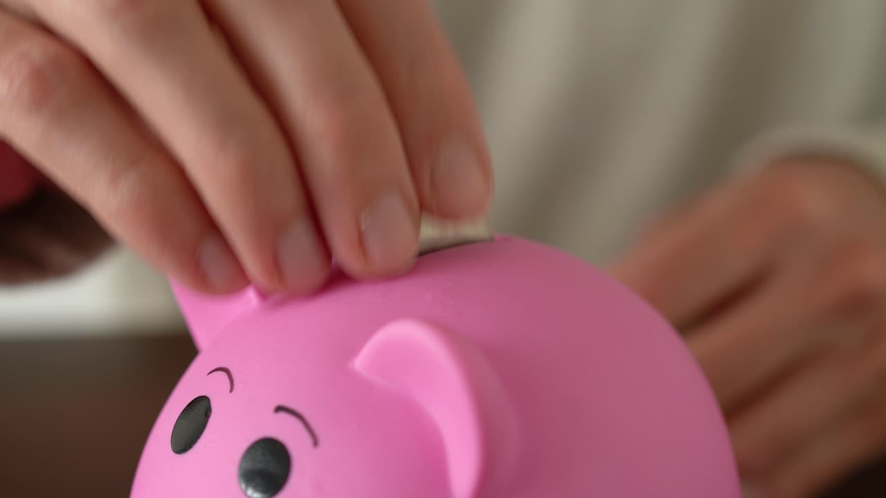 hombre guardando varias monedas de plata en una alcancía