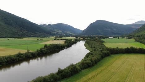 drone tilt up from farm to fjord and mountains