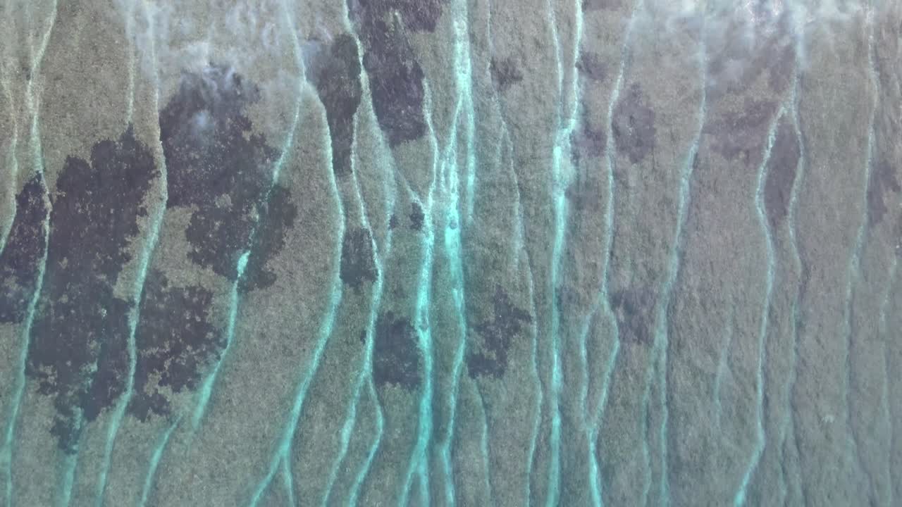 Aerial View of Ocean Waves Receding Over Coral Reef