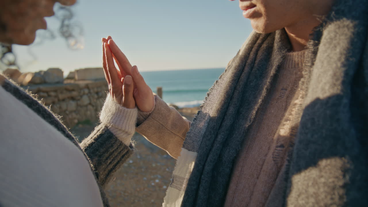 Love couple hands connecting in ocean closeup. Diverse man woman bonding palms