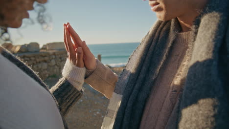 love couple hands connecting in ocean closeup. diverse man woman bonding palms