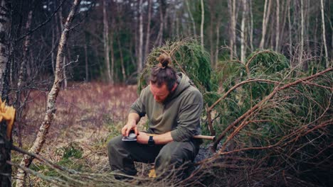 a man sharpening an axe in the woods. static shot