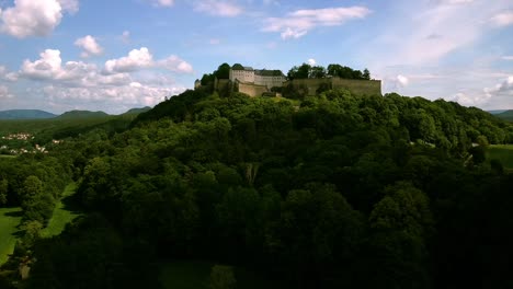drone footage circling around a majestic castke on the hill at middle altitude with cloudy skies in central europe