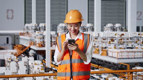 trabajadora de una fábrica que usa un teléfono inteligente