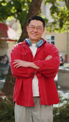 happy asian man smiling looking at camera dreaming resting good news feel satisfied in city street