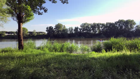 Un-Día-Soleado-Con-Algunas-Nubes-Blancas,-Disfrutando-De-Las-Vistas-Del-Bosque-Y-El-Río-En-Kayak